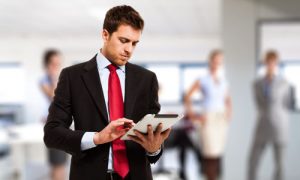 Image of a Patent Attorney Standing and Checking with his Tablet.