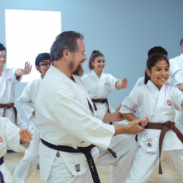 Image showing happy coach given karate training to his students in a training session.