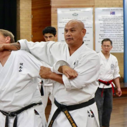 Image Showing Master Teaching Defending Knifehand Technique To Their Students.