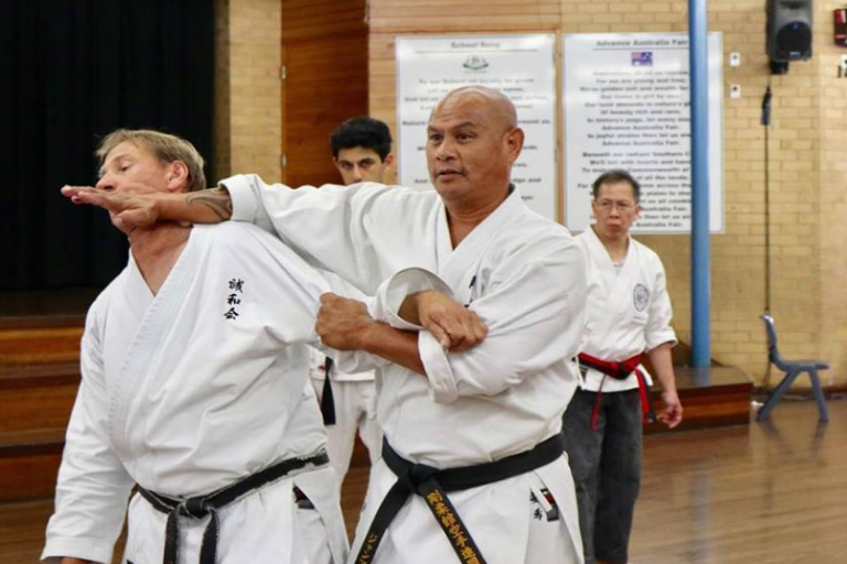 Image Showing Master Teaching Defending Knifehand Technique To Their Students.