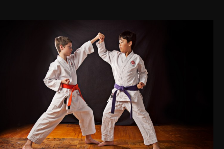 Image Showing Two Kids Practicing Their Defending Techniques Against a black background.