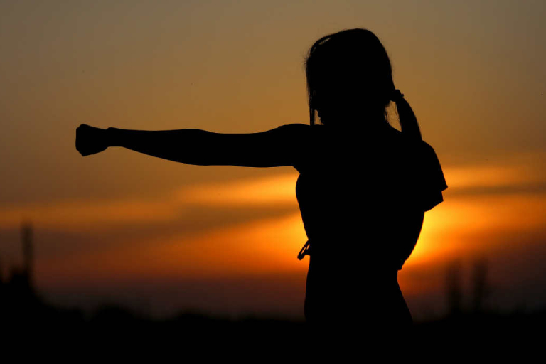 A Silhouette Of Young Woman On Her Martial Art Training In The Early Morning.