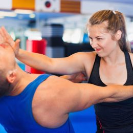 Bold Positive Woman Is Training With Man On The Self-Defense Course In Gym.