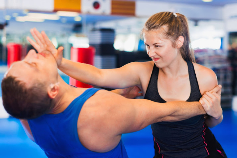 Bold Positive Woman Is Training With Man On The Self-Defense Course In Gym.