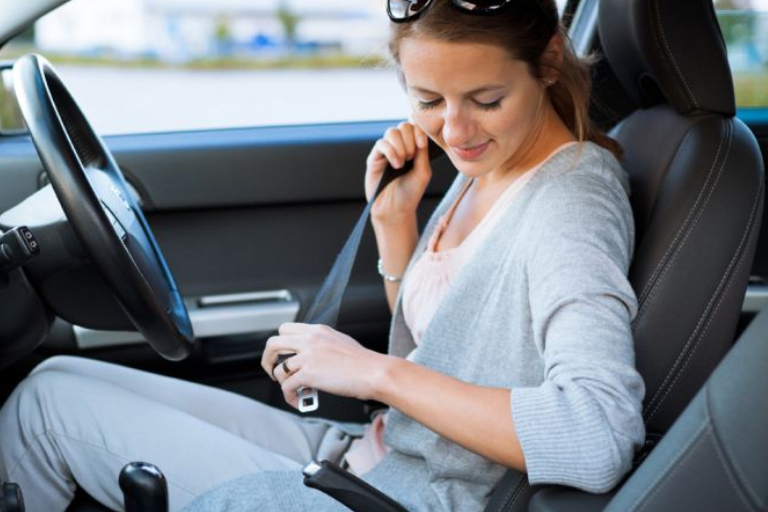 A Young Woman Wearing Her Seat Belt Before Start Driving.