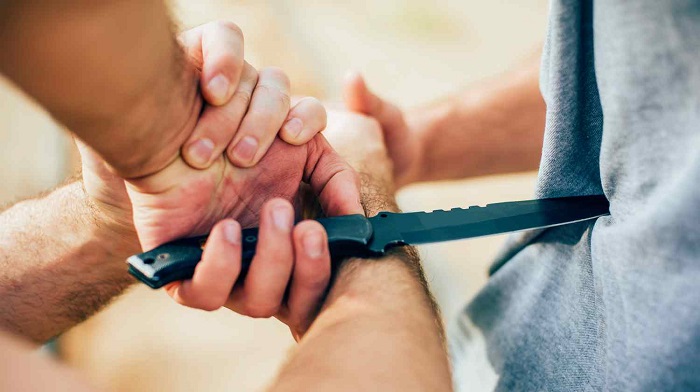 Instructor Demonstrates Martial Arts Self Defense Knife Attack Disarming Technique.