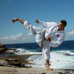 A Man Doing karate Stance In A Beach Shore.