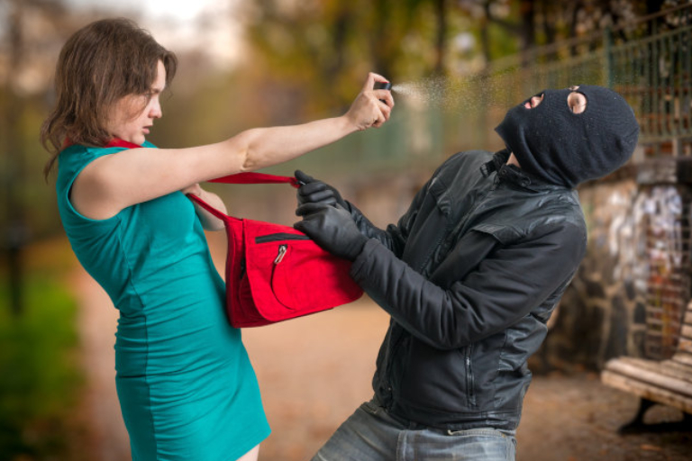 A Woman Defending A Robber By Pepper Spray.