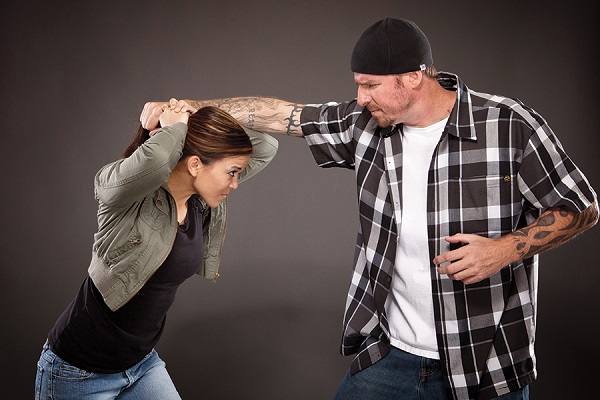 A Young Woman Defending The Person Who Pulling Her Hair.