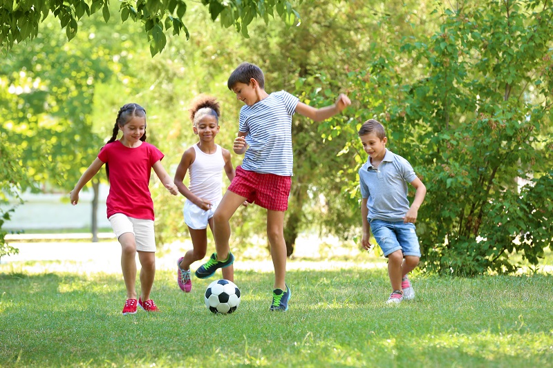 Young kids were playing football in home garden.